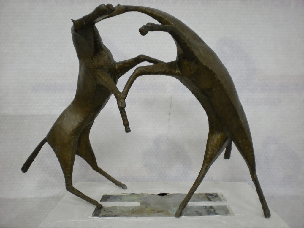 Bronze sculpture of two stylized horses facing each other, their raised forelegs touching