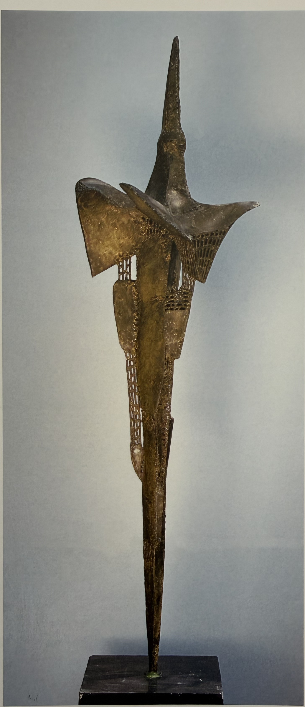 Haute sculpture d’oiseau en laiton, à la partie supérieure pointue et aux ailes déployées, avec des grilles ajourées dans son corps étroit
